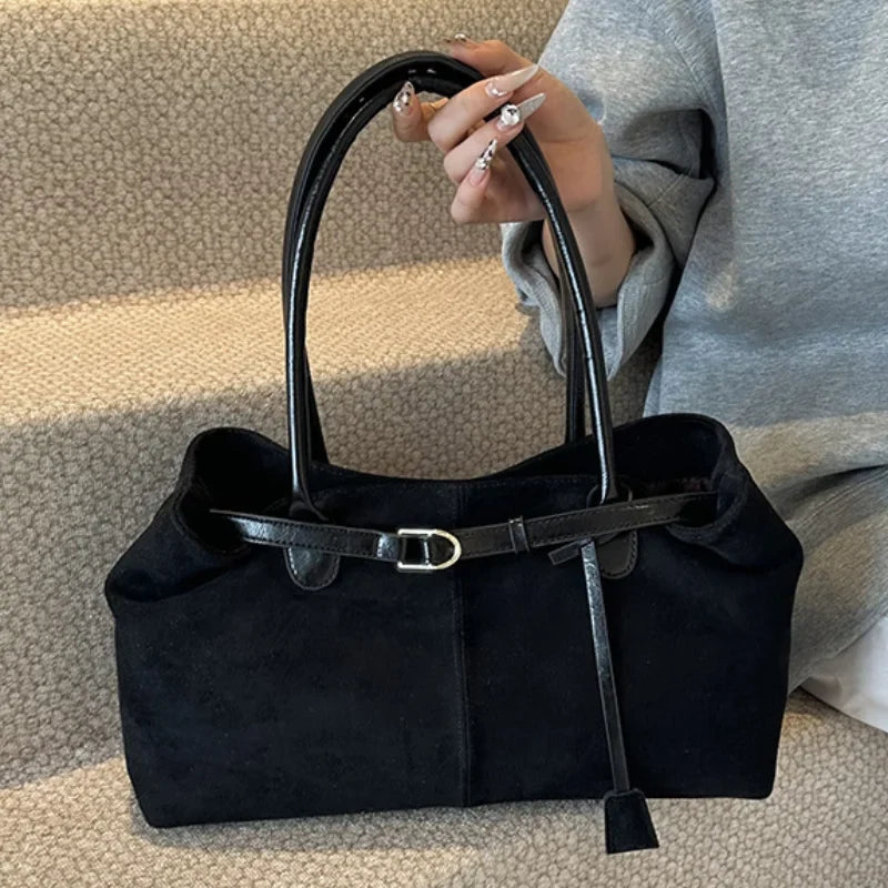 Sac à main femme en suédine noire, accessoire de mode élégant et intemporel.