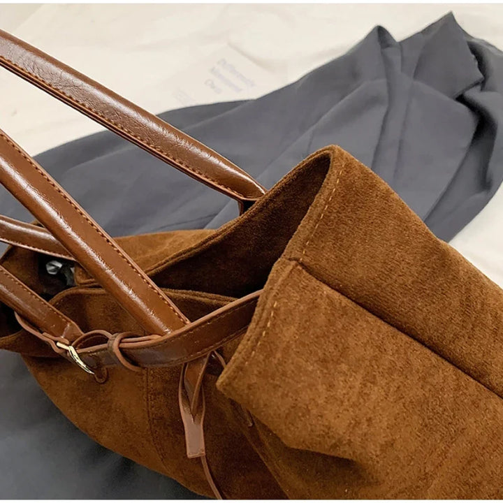 Sac à main suédine noir, accessoire élégant et polyvalent pour la mode féminine.