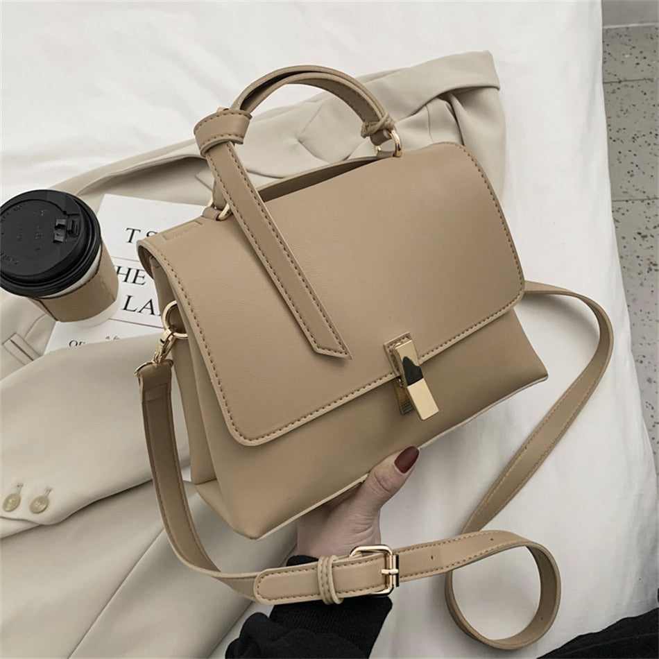 Sac à main trapèze marron avec bandoulière réglable, posé sur une surface, montrant sa forme et sa texture