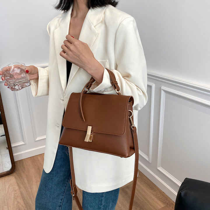 Gros plan sur la texture du similicuir grainé d'un sac à main trapèze beige, détails des coutures fines