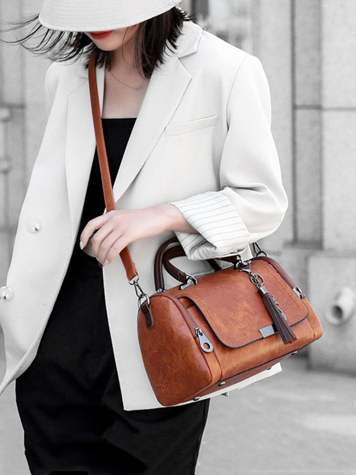 Détail du sac à main 'Sophie' en cuir marron, texture douce, fermoir doré élégant