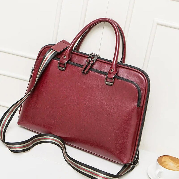 Sac ordinateur professionnel en cuir pour femme, avec compartiments pour portefeuille et accessoires.