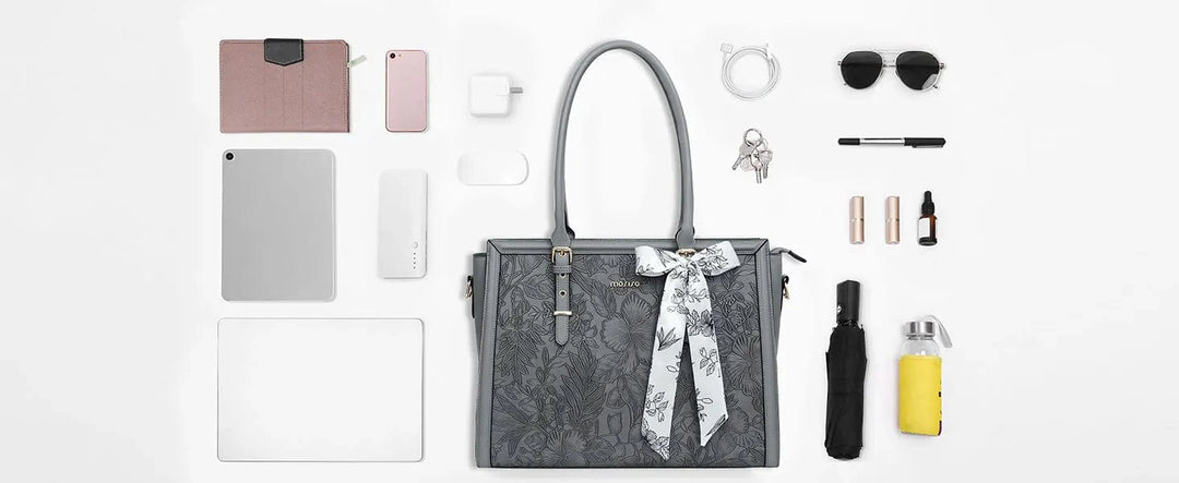 Composition d'un sac ordinateur femme en cuir PU noir avec un ordinateur portable et des documents, prêt à l'emploi.