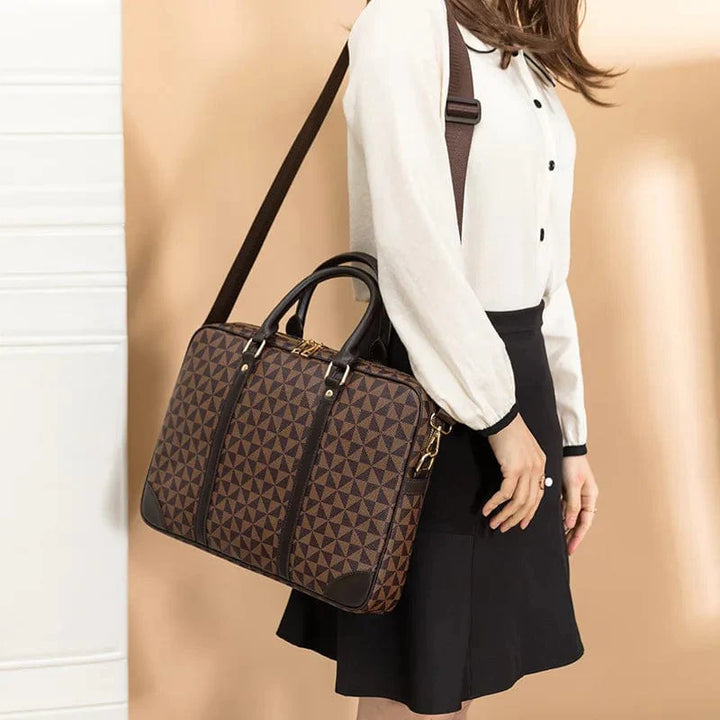 Sac à main ordinateur femme, noir, avec détails dorés, offrant un look raffiné pour transporter un ordinateur portable.