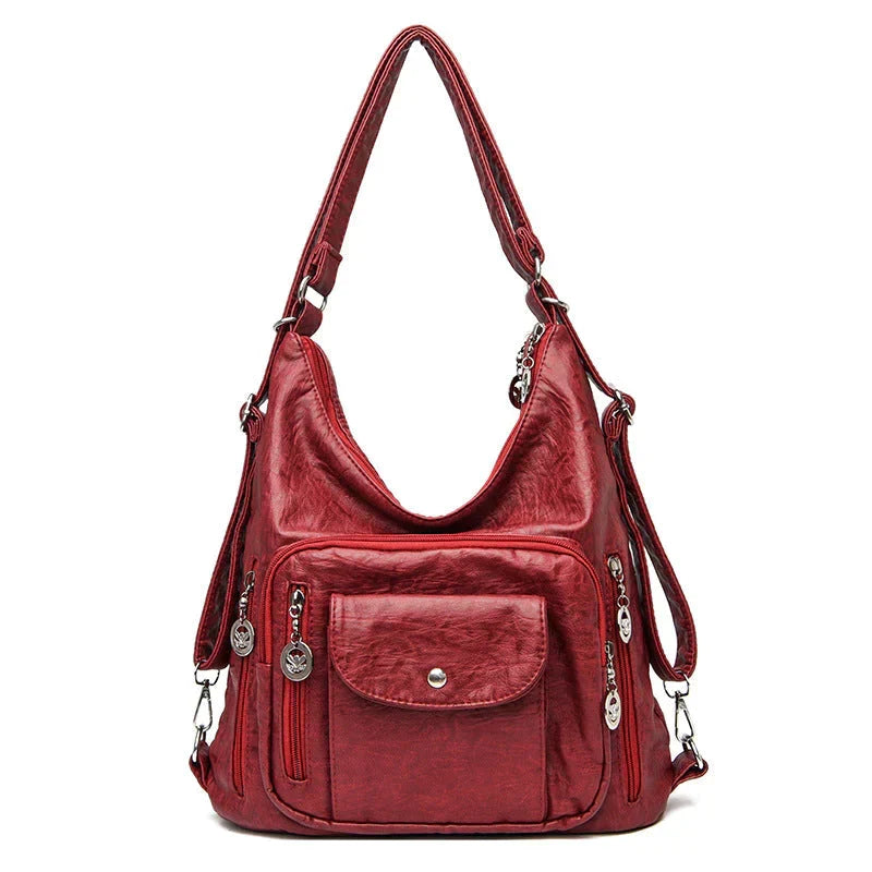 Sac bandoulière femme en cuir souple noir, porté élégamment, accessoire chic pour le quotidien.
