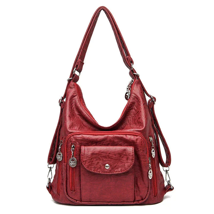 Sac bandoulière femme en cuir souple noir, porté élégamment, accessoire chic pour le quotidien.