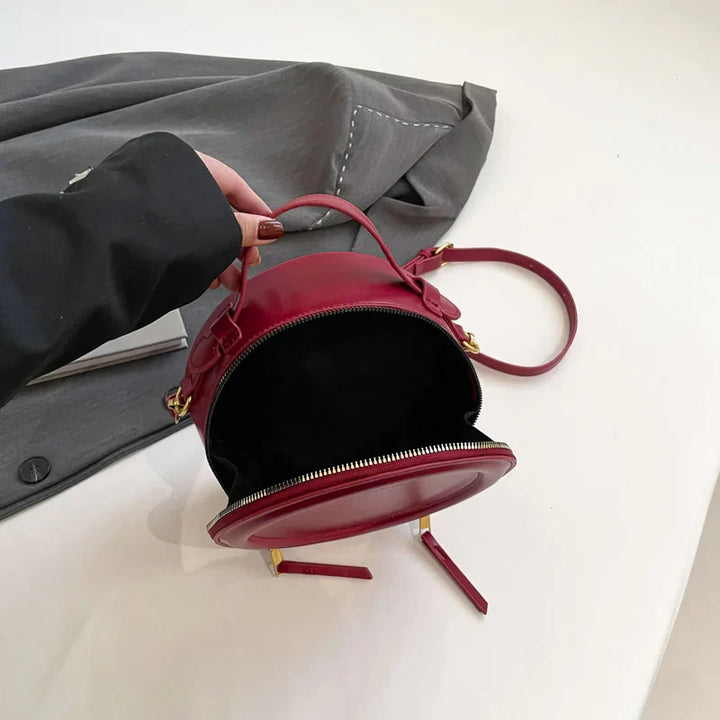 Sac rond femme porté épaule, bandoulière ajustable, cuir synthétique rose poudré, touche féminine