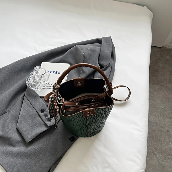 Sac seau en cuir vegan tressé porté par une femme, illustrant sa taille et son style décontracté chic.