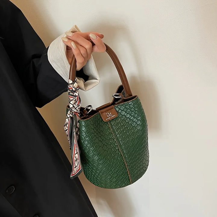 Fermeture du sac seau tressé en cuir vegan, système de cordon coulissant sécurisé et stylé.