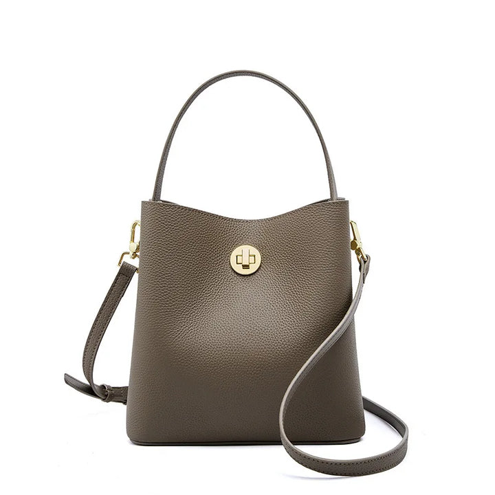 Sac seau élégant en cuir grainé beige pour femme. Accessoire chic de maroquinerie avec bandoulière.