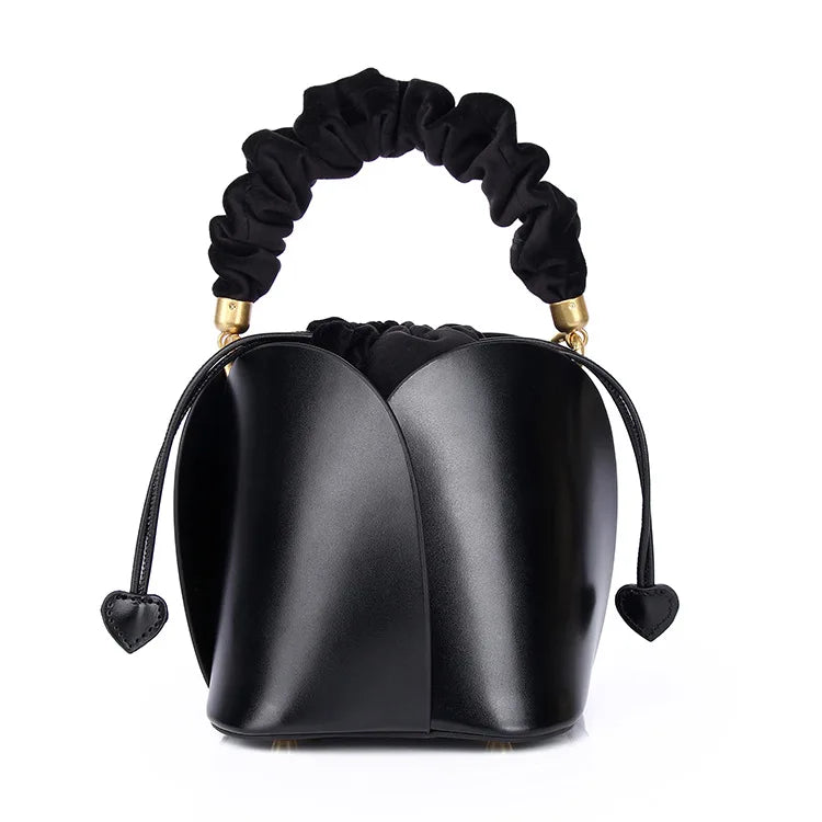 Sac seau femme en cuir vachette bleu, vue de côté. Design épuré, parfait pour toutes occasions.