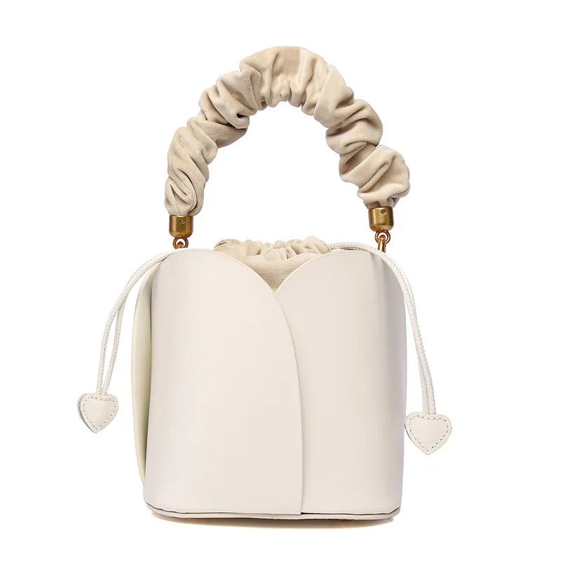 Sac seau élégant en cuir vachette vert, posé. Choix de couleurs pour un accessoire de mode unique.