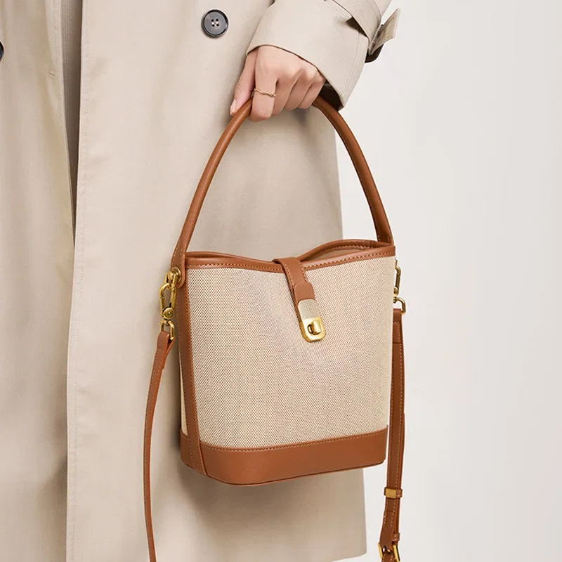 Sac à main seau marron sophistiqué avec bandoulière, en cuir synthétique pour un style moderne.