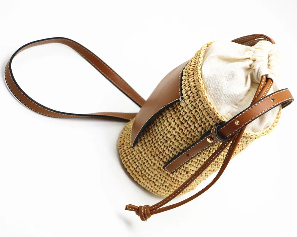 Sac de plage beige en paille naturelle, forme seau, pour femmes, très chic.