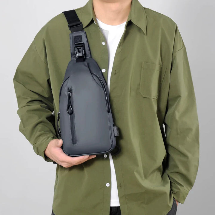 Sac épaule homme noir, tissu imperméable, format compact et léger, idéal pour les loisirs et la ville.