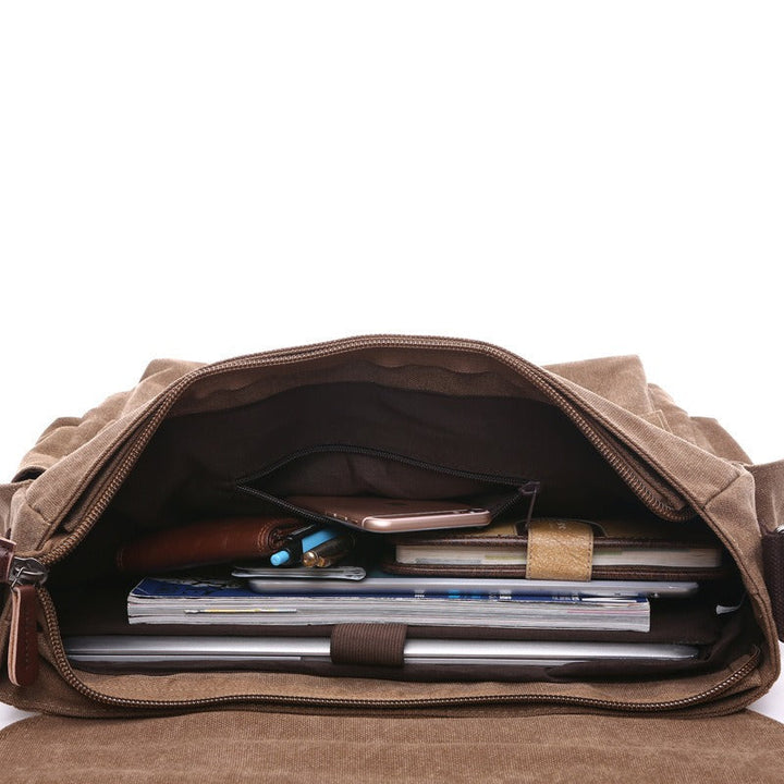 Gros plan sur la toile résistante et le similicuir vieilli du sac à bandoulière homme, détails vintage.