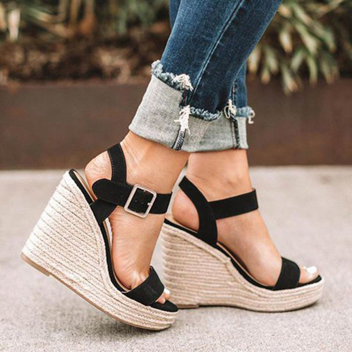 "Sandales compensées élégantes Holly pour femmes, en cuir avec bride, disponibles en marron, noir et argent. Confort assuré."