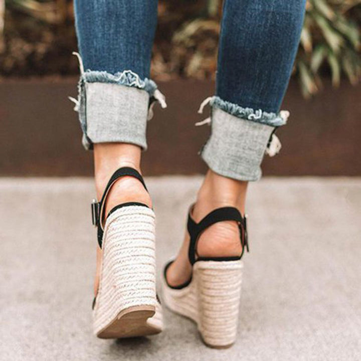 "Sandales compensées élégantes Holly pour femmes, en cuir avec bride, disponibles en marron, noir et argent. Confort assuré."