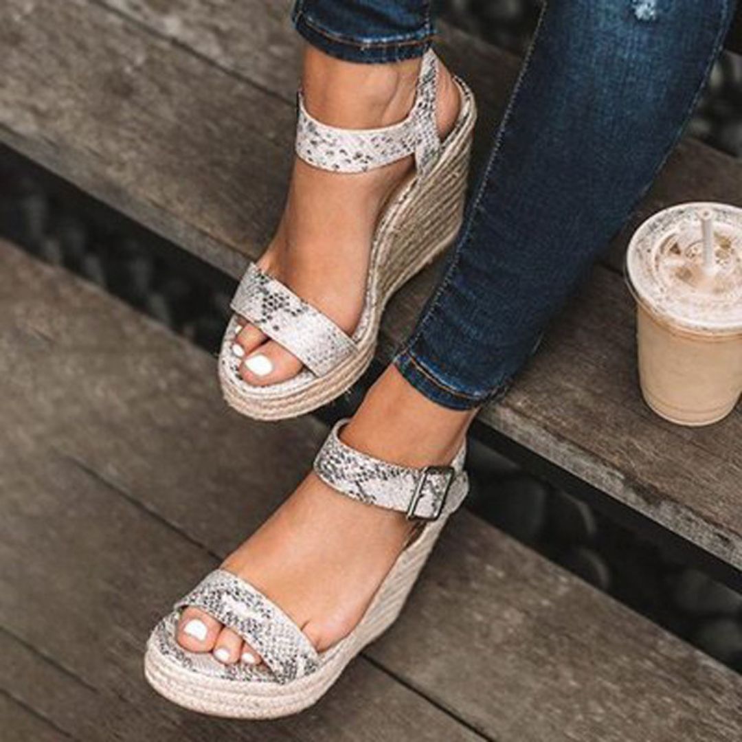 "Sandales compensées élégantes Holly pour femmes, en cuir avec bride, disponibles en marron, noir et argent. Confort assuré."
