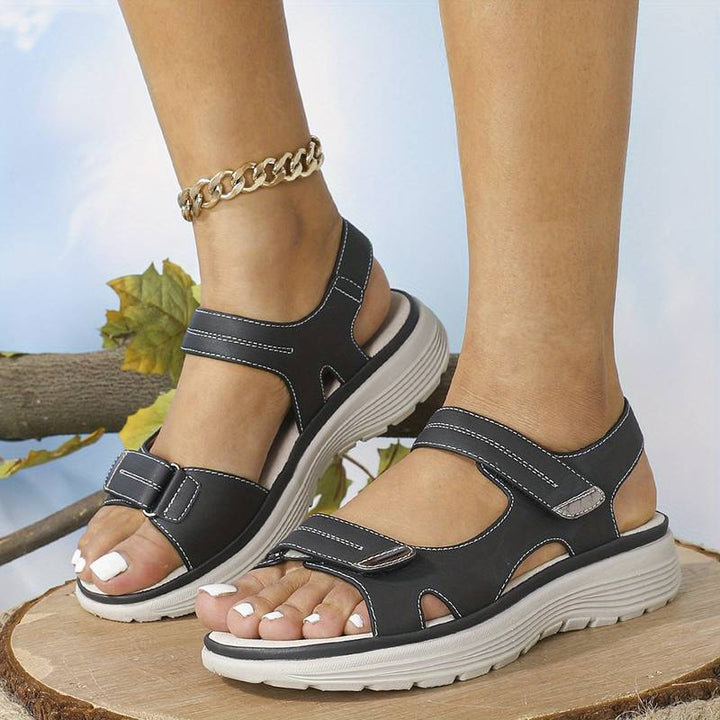 Pied de femme portant des sandales orthopédiques élégantes et confortables, parfaites pour un look estival mode.