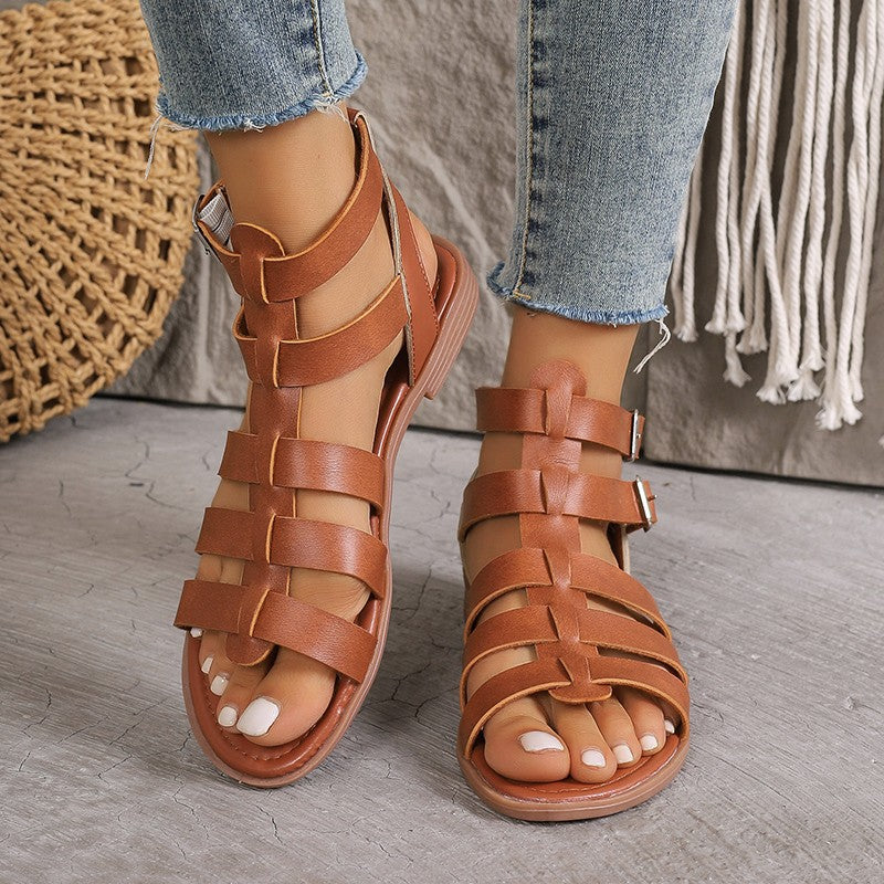Sandales plates femme en similicuir style romain, boucles réglables, bout ouvert, look estival et décontracté.