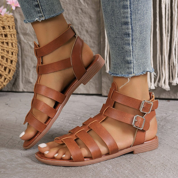 Sandales plates femme en similicuir style romain, boucles réglables, bout ouvert, look estival et décontracté.