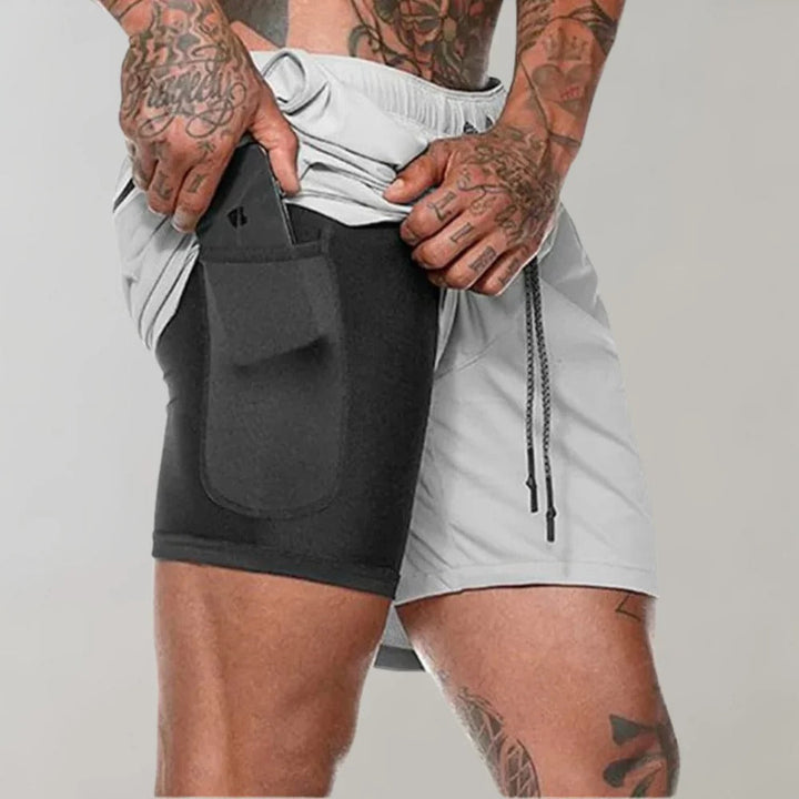 Homme en action portant un short d'entraînement noir avec compression, idéal pour la performance sportive.