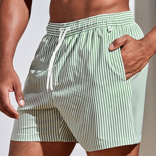Short de bain rayé, coupe ajustée, séchage rapide.  Parfait pour la plage et la piscine.