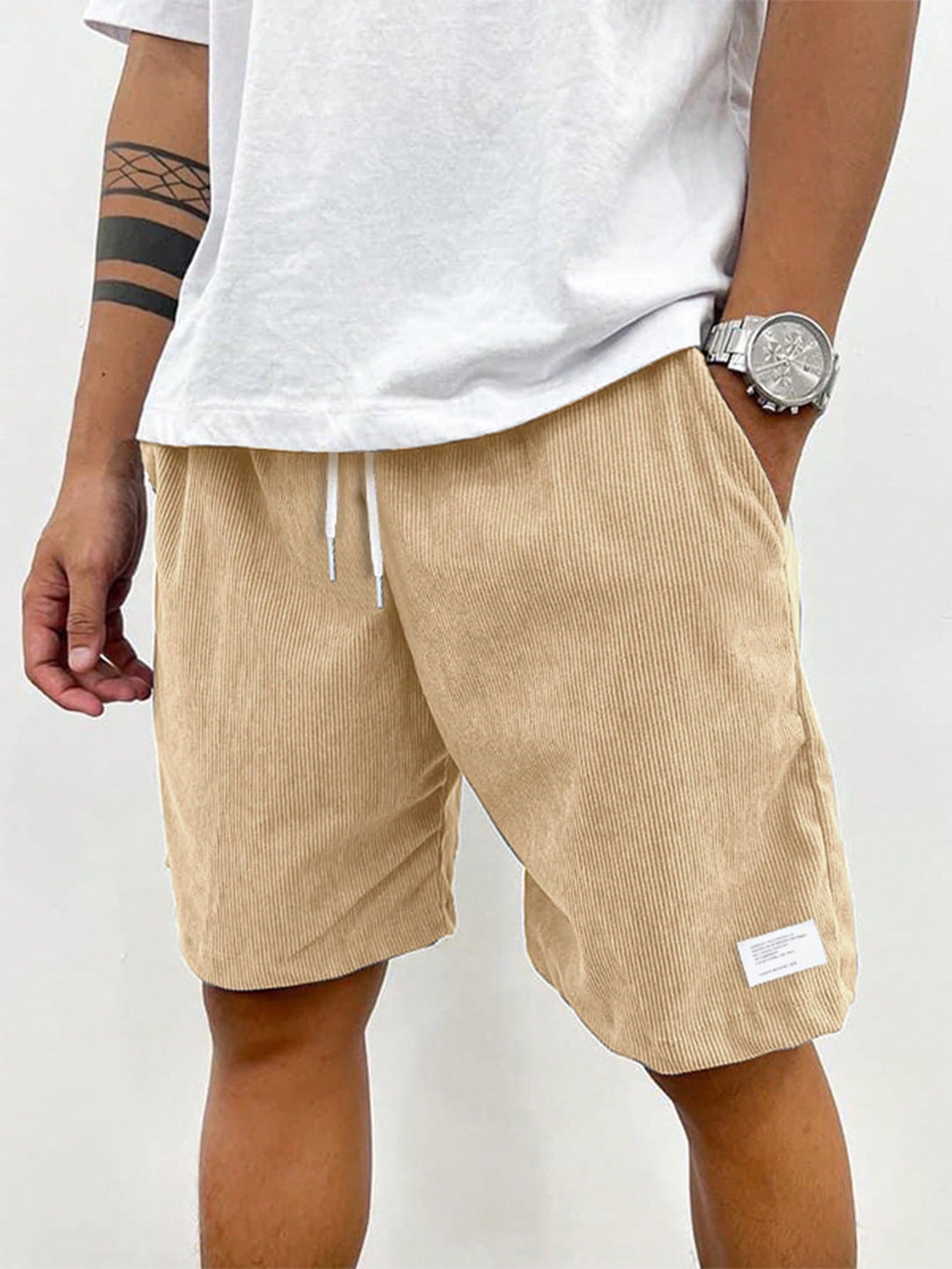 Homme stylé en short velours côtelé stretch et t-shirt, look décontracté chic pour l'été.