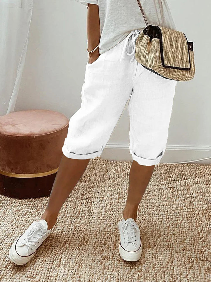 Shorts courts pour femmes en coton et lin, taille élastique rose, poches latérales. Offre un confort estival et un style rela