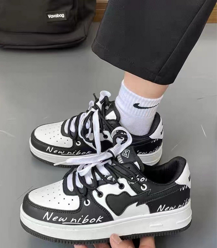 Paire de sneakers femme à motif cœur, chaussures confortables et stylées pour la mode urbaine et casual.