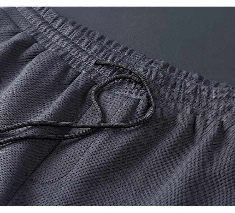 Vêtement de sport homme: survêtement noir chic, veste à col zippé et pantalon slim pour style décontracté.