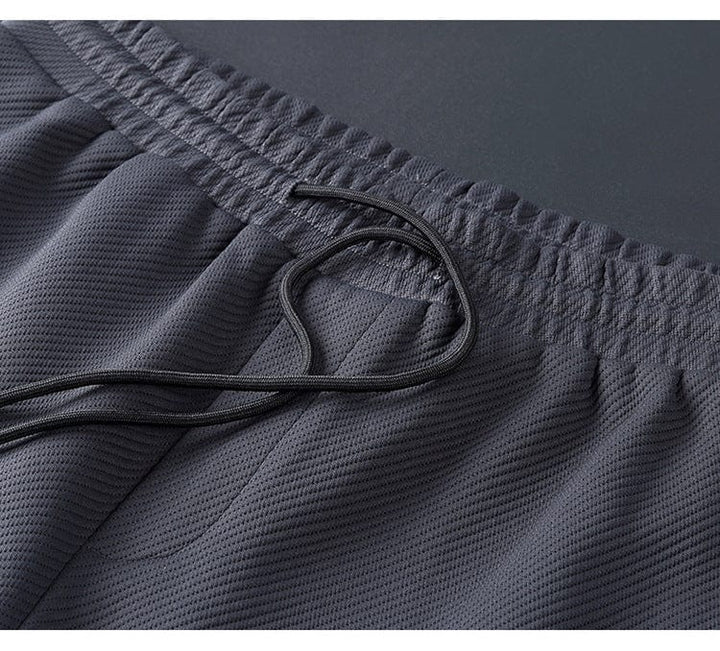 Vêtement de sport homme: survêtement noir chic, veste à col zippé et pantalon slim pour style décontracté.
