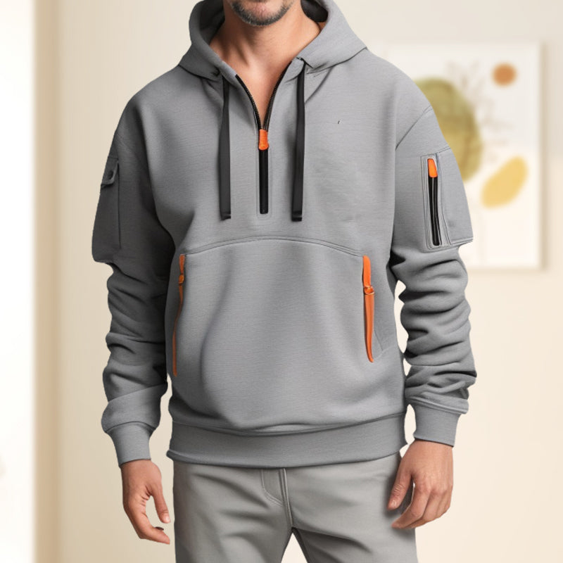 Gros plan sur le demi-zip d'un sweat à capuche homme, qualité, modernité et finition.