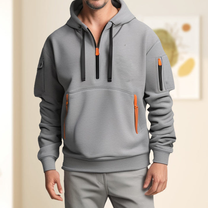 Gros plan sur le demi-zip d'un sweat à capuche homme, qualité, modernité et finition.