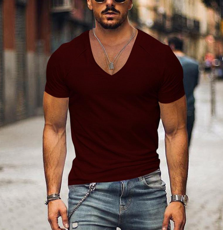 Modèle masculin portant un t-shirt col V blanc, look épuré et moderne. T-shirt décontracté basique et élégant.