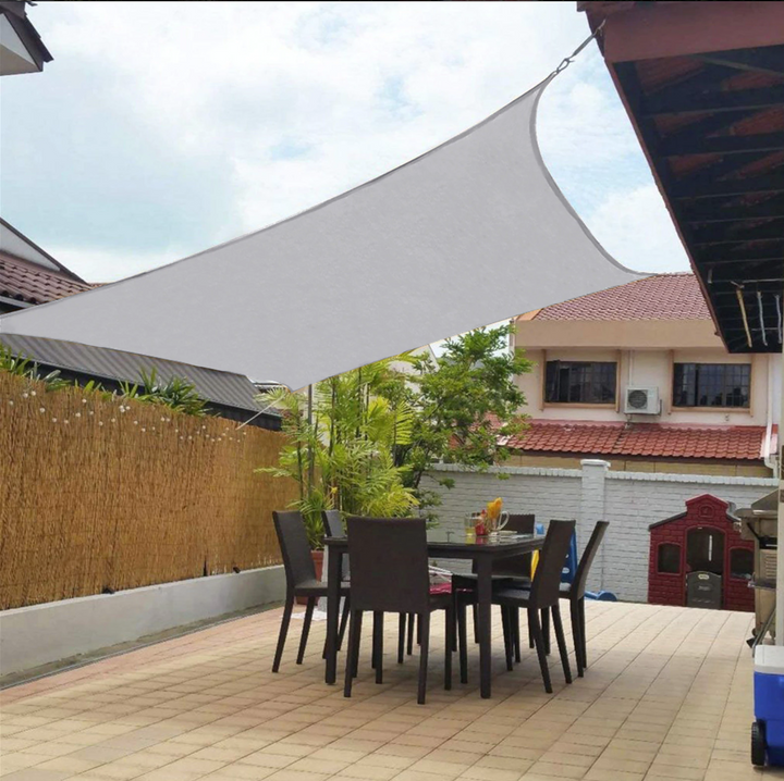 "Toile d'ombrage beige luxueuse imperméable, installée sur terrasse extérieure, protection UV et élégance contemporaine."