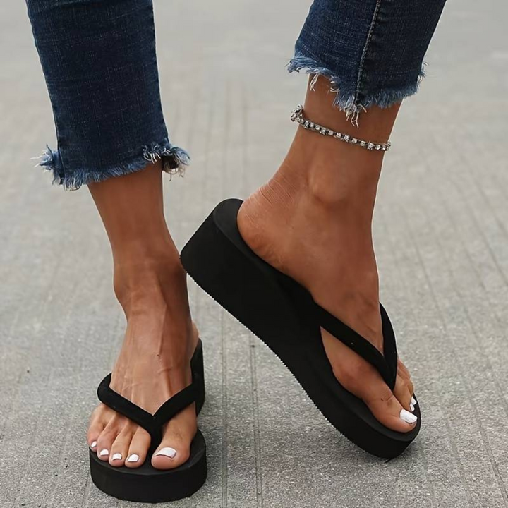 "Tongs femme à talon compensé, élégance estivale, semelle rembourrée et bride souple pour confort décontracté."