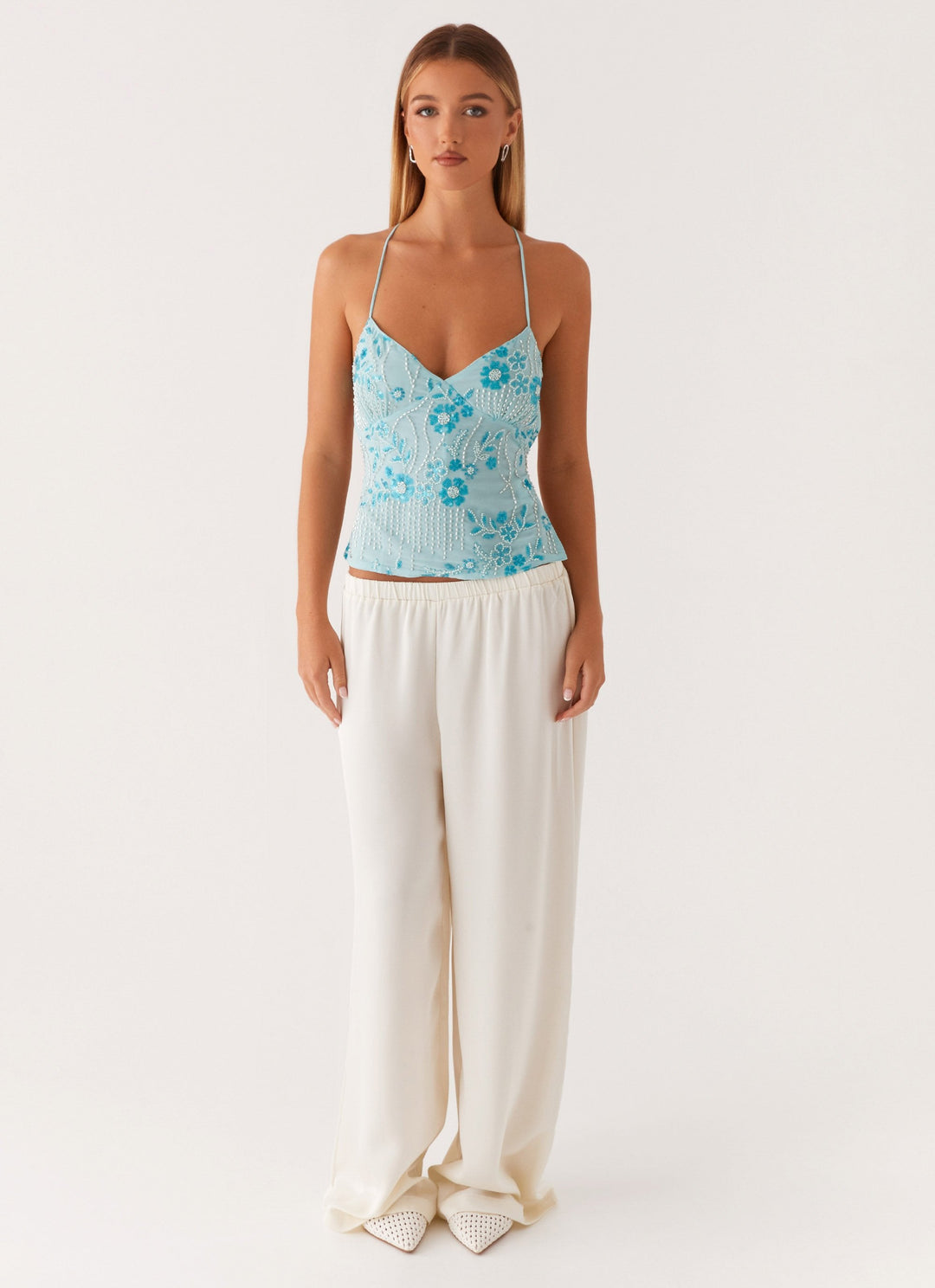 "Top cami à sequins fuchsia avec dos nu et bretelles croisées, idéal pour un look glamour et chic lors d'une soirée."