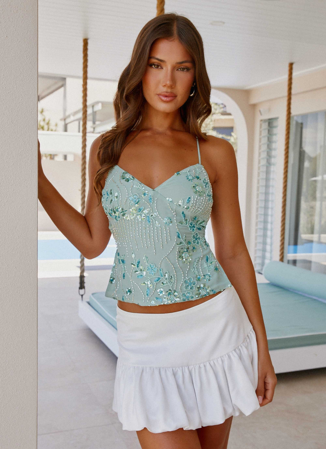 "Top cami à sequins fuchsia avec dos nu et bretelles croisées, idéal pour un look glamour et chic lors d'une soirée."