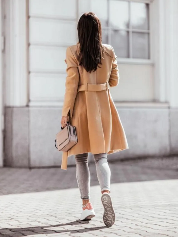 Trench-coat femme ajusté beige, style intemporel. Vêtement extérieur élégant pour l'automne et la saison froide.