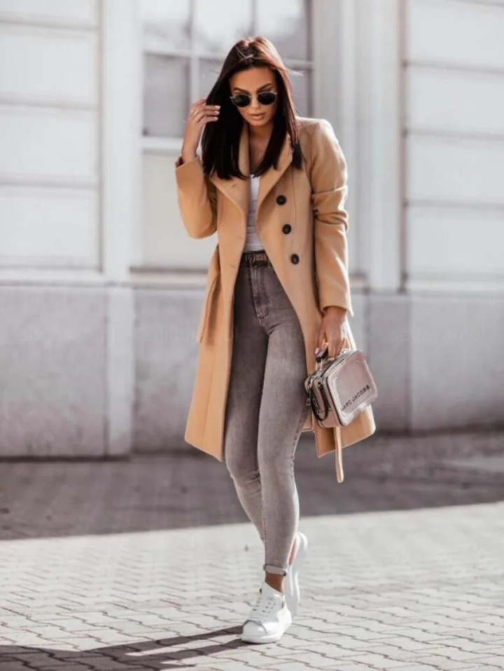 Femme en trench-coat chic, vêtement extérieur automnal. Manteau féminin élégant, coupe classique et style intemporel.