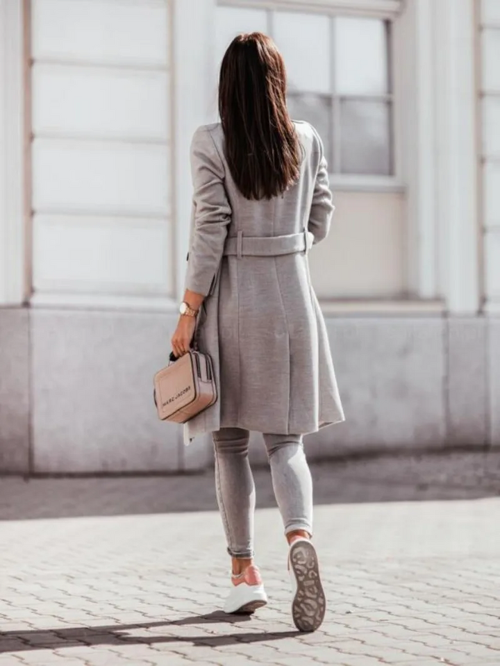 Trench-coat femme intemporel, style classique pour l'automne. Manteau chic ajusté, mode féminine élégante et polyvalente.