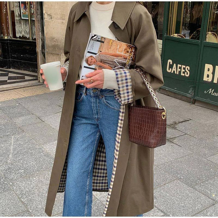 Veste trench longue femme kaki, pièce tendance et chic pour un look mode automne élégant.