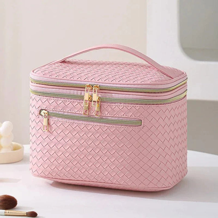 Détail de la texture du cuir PU grainé d'une trousse de toilette de luxe, avec un logo discret pour femme.