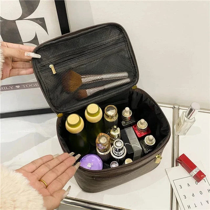 Trousse de toilette femme fermée en cuir PU kaki, posée sur une surface neutre