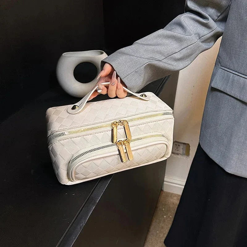 Trousse de toilette femme en cuir PU beige, ouverte, révélant son intérieur spacieux et ses compartiments
