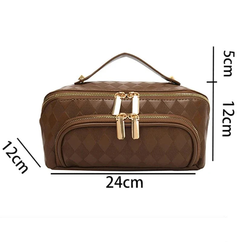 Trousse de voyage femme grande capacité en cuir PU marron, posée sur une surface en bois clair