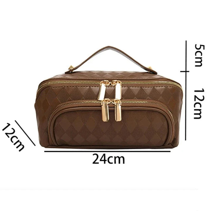 Trousse de voyage femme grande capacité en cuir PU marron, posée sur une surface en bois clair