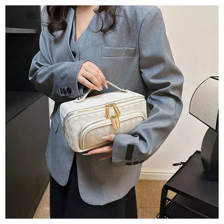 Gros plan d'une trousse de toilette femme en cuir PU, montrant la texture du cuir et la qualité de la couture
